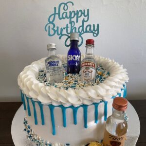 Custom made birthday cake with mini whisky bottles and chocolate topping.